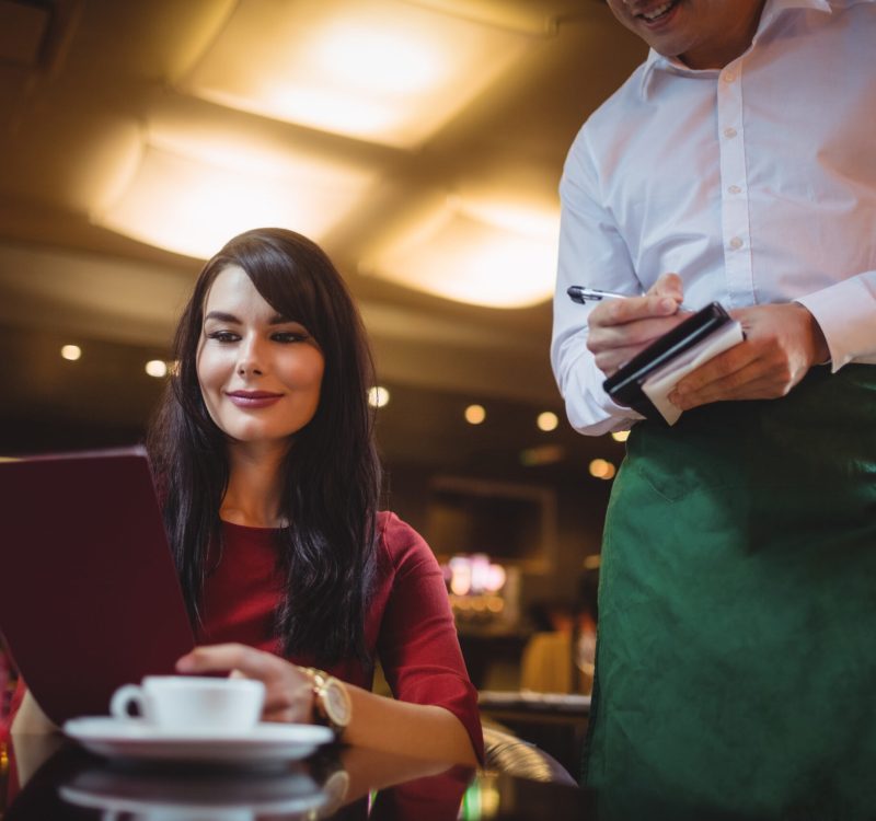 Waiter taking order from woman in a restaurant